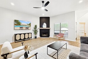 Cozy living room with a fireplace, perfect for watching movies or relaxing. Beautiful lighting and comfortable seating.
