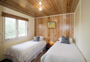 Share a peaceful retreat in this charming bedroom, featuring twin beds perfect for relaxation.