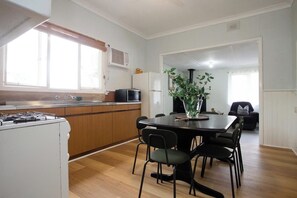 Prepare delicious meals in this well-equipped kitchen, boasting a stove, oven, and a dining area perfect for enjoying meals together.
