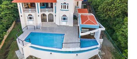 House with tropical greenery, territory, swimming pools and ocean views.