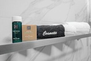 Stylish bathroom with elegant tilework and complimentary toiletries.