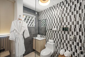 Relax and unwind in this contemporary bathroom, featuring a sleek design, beautiful tilework, and a plush robe for ultimate comfort.

