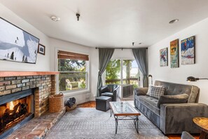 Living room: Wood-burning fireplace, sofa and TV