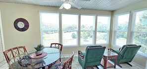 Beautiful sunroom with ample seating and a gorgeous view of the golf course!
