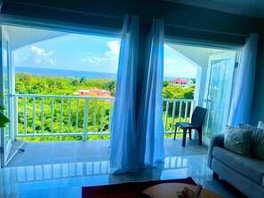 Step into a serene oasis in our stunning indoor-outdoor living room. Floor-to-ceiling glass balcony doors invite the captivating ocean views and gentle sea breezes. blending the comforts of home with the beauty of nature.
