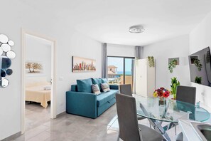 Livingroom with Dining Table, Sofa Bed, Flatscreen TV, and Balcony View