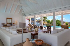 Spacious living room, nicely decorated and completely opened on the terrace with the swimming pool, large sofas, ceiling fan. 