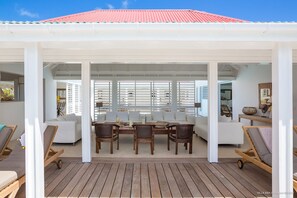 Spacious living room, nicely decorated and completely opened on the terrace with the swimming pool, large sofas, ceiling fan. 