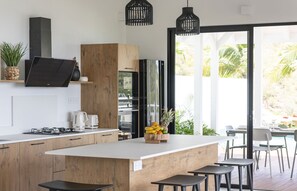Modern and fully equipped kitchen, breakfast bar with 3 stools, air-conditioning, ceiling fan, gas stove, oven, microwave, blender, coffee maker, fridge, freezer, ice maker, juicer, Nespresso coffee machine, toaster. Outside dining table on the covered te