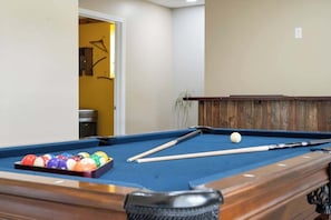 How about a game of pool? The downstairs den area features a small bar, mini fridge, and a pool table, providing plenty of fun and entertainment for the whole family.