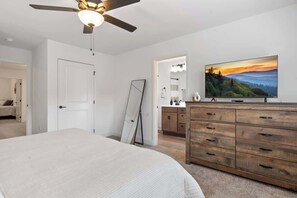 The main bedroom has a full bath, a flat-screen TV, full body mirror, and ample storage with a closet and dresser. Enjoy the plush linens and bedding for a restful night's sleep or a quick nap.