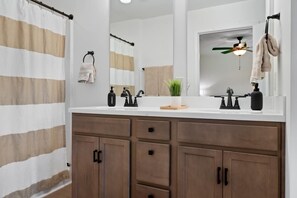 Main bathroom, an en-suite to the king bedroom with a double vanity, walk-in shower, toilet, and a small linen closet stocked with soaps, shampoo, conditioner, and a hair dryer. It's perfect for getting ready for your big adventure.