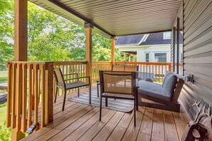 Large front porch with lounge chairs and views of park across the street. 