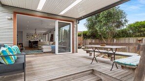 Spacious outdoor deck with ample seating and a BBQ. 