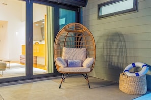 Stylish fold-up doors open to a cozy egg chair for relaxing day or night.