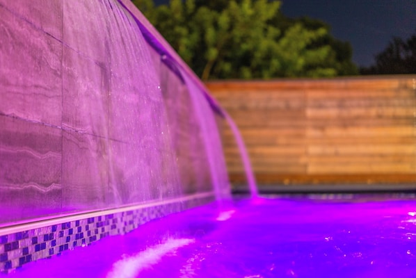 Heated pool with cascading waterfall, perfect for a relaxing, serene retreat.
