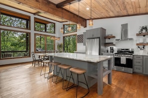 A large island with barstools, and a dining table with seating for eight.