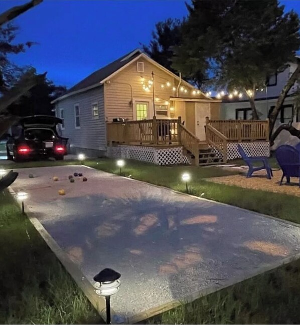 Backyard has a large deck with seating, a fire pit, and bbq
