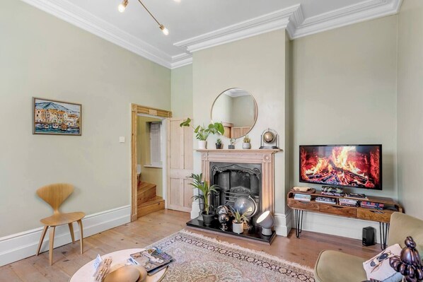 Cosy up in the inviting living room, featuring a comfortable sofa, and a large TV for your entertainment. Perfect for relaxing after a day of exploring! 🔥🛋📺