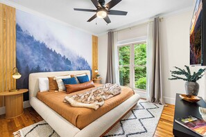 Unwind in the King bedroom on the main floor, featuring a mural of a forest.