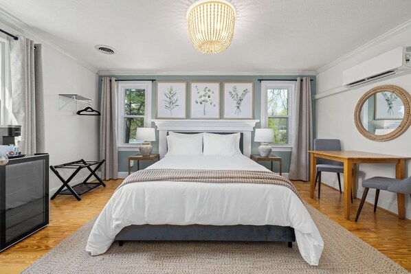 Bedroom 1: queen bed, dresser, TV, table + chairs, mini fridge, & Keurig
