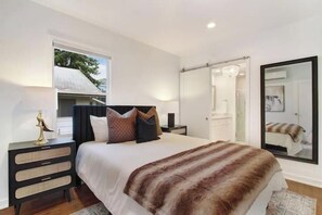 Bedroom with large attached bath, full mirror, and spacious closet.