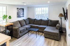 Living Room: Nestled in warmth and elegance, this cozy living room features plush, inviting sofas, a crackling fireplace, and soft, ambient lighting.