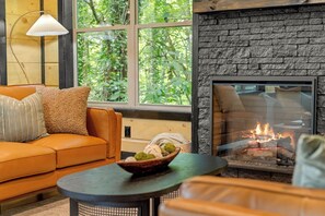 A contemporary black stone fireplace serves as the focal point of the room, creating a warm and inviting atmosphere.