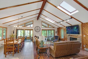 Spacious living room with smart TV, gas fireplace, sunroom, and deck access.