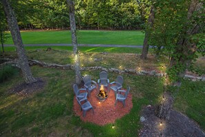 Fire pit with Adirondack chairs adjacent to the golf course perfect for S'mores.