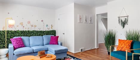 Living room with eclectic couch, airy ambience, and plush couch