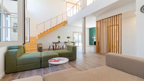 Spacious living room with natural light, stylish seating, and easy access to upstairs bedrooms. #NaturalLight #ModernDesign