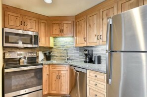 Well-equipped kitchen with stainless steel appliances and wooden cabinets.