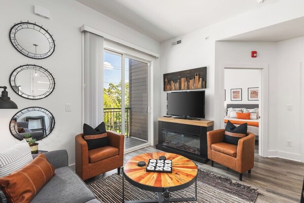 Comfy living room with a full-size pull-out couch, electric fireplace, Smart TV with all the streaming apps and your own private balcony.