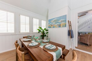 The dining room is ideal for family meals, game nights, and beachside memories