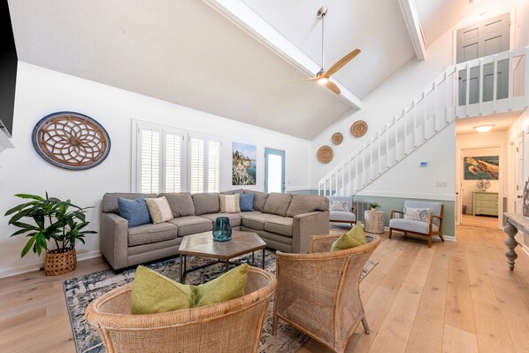 Bright and open living room with vaulted ceiling and wide plank hardwood floors