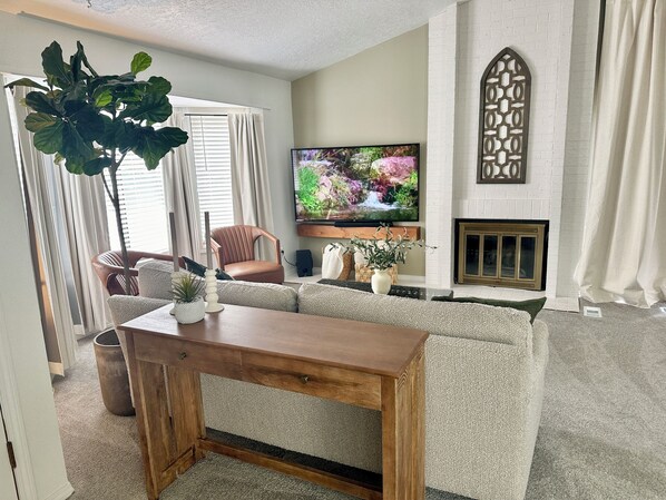 Cozy living room with a fireplace and 60” smart TV. 
