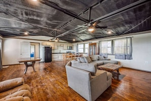 The expansive living room offers plenty of space to gather and relax. With comfortable seating and a welcoming atmosphere, it’s the perfect place to unwind with family or friends.