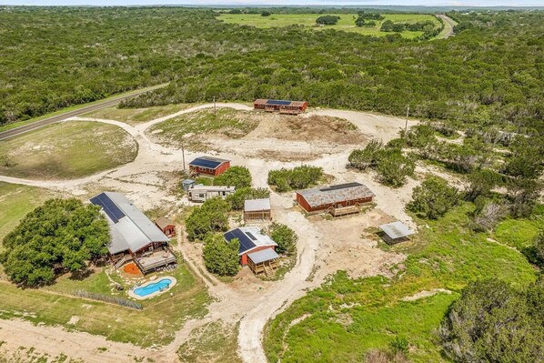 Take in the beautiful aerial view of the entire property, showcasing the layout of the cabins and the surrounding land. This perspective highlights the serene and expansive setting that makes for the perfect getaway.