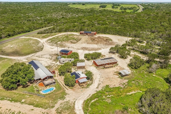 Take in the beautiful aerial view of the entire property, showcasing the layout of the cabins and the surrounding land. This perspective highlights the serene and expansive setting that makes for the perfect getaway.