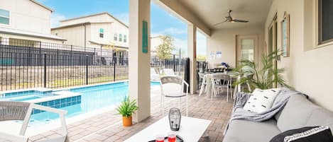 Relax by the pool in a breezy, cozy patio with stylish outdoor seating.