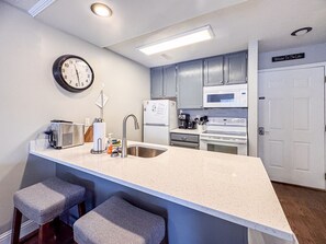 Modern kitchen with bar seating and all essentials, perfect for cooking and casual conversation