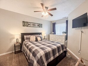 Cozy bedroom with a plush bed, soft lighting, and a TV for relaxing evenings.