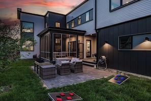 Our backyard features outdoor seating, a grill, and cornhole ready for you to play your next match!