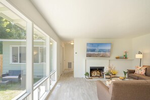 Living Room has a Gas Fireplace, TV and a Wall of Windows