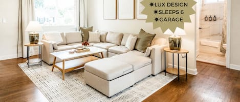 Unwind in the bright and airy living room, featuring a spacious sofa. Enjoy abundant natural light streaming through the windows as you relax and enjoy the big-screen smart TV. Update: Recliner added for Comfort and Recovery.
