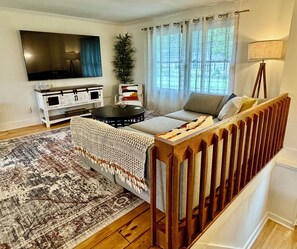 Living area with large flat screen tv that rotates, spacious couch and chair