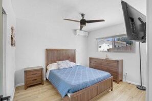 Bedroom Two with Queen bed, Flatscreen TV, AC, and lots of natural sunlight.