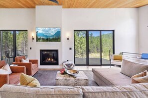 This welcoming living room is designed for relaxation, with a large sectional and two adjoining chairs offering plenty of seating for everyone. The stylish coffee table is a convenient spot for your tea or snacks, making it the perfect setting for unwinding and lounging.