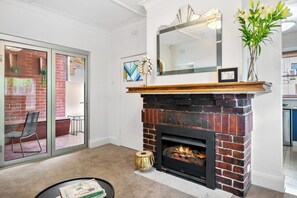 APARTMENT 2 LIVING ROOM: The Living Room doors open up completely on to an outdoor deck that creates a perfect large space for entertaining. A cosy gas fireplace heats the apartment.